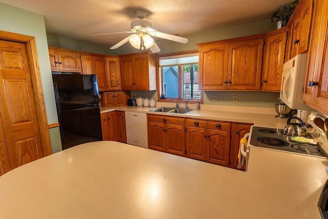 kitchen with ceiling fan, sink, white appliances, and a textured ceiling