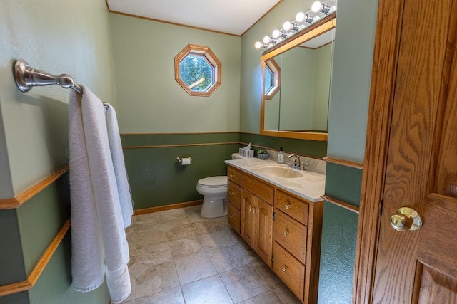 bathroom with vanity, toilet, and ornamental molding