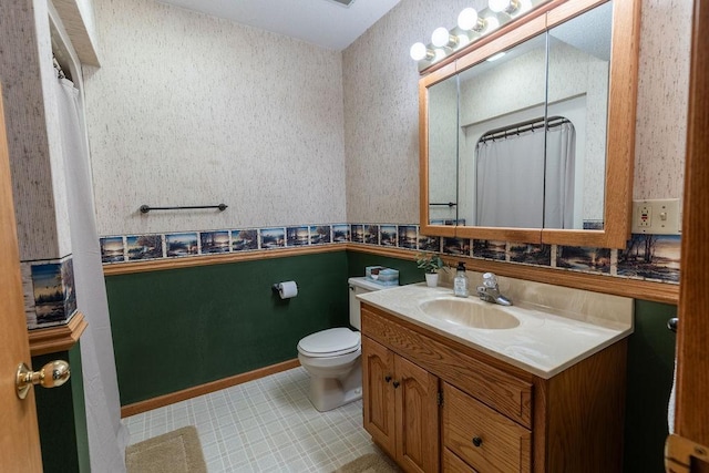 bathroom with toilet, vanity, and curtained shower