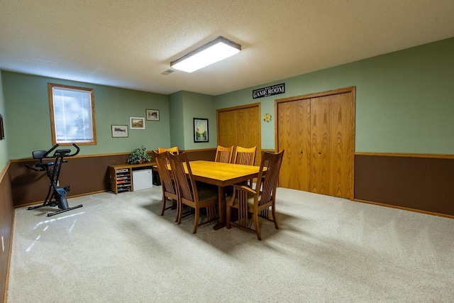 dining space featuring a textured ceiling and light carpet