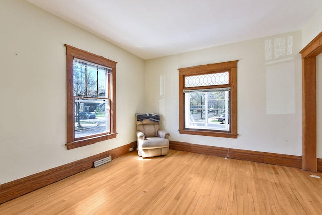 sitting room with baseboards and light wood finished floors