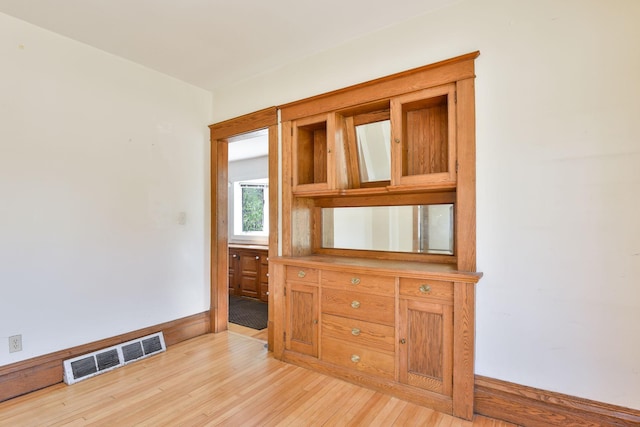 empty room featuring light wood finished floors and visible vents