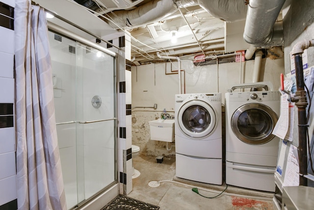 washroom featuring a sink, laundry area, and washing machine and dryer