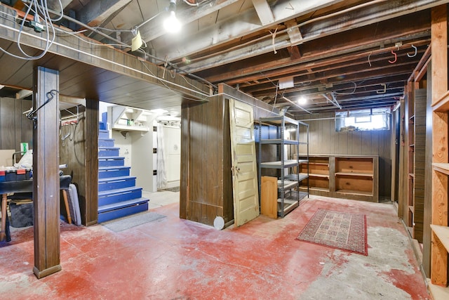 basement with wooden walls and stairway