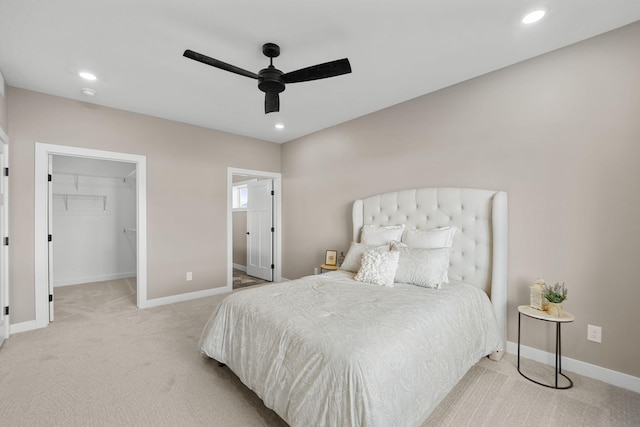 carpeted bedroom with a closet, a spacious closet, and ceiling fan