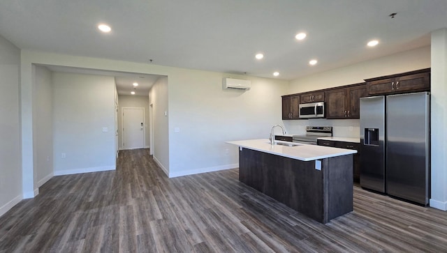 kitchen featuring appliances with stainless steel finishes, dark hardwood / wood-style flooring, a wall mounted air conditioner, sink, and a kitchen island with sink