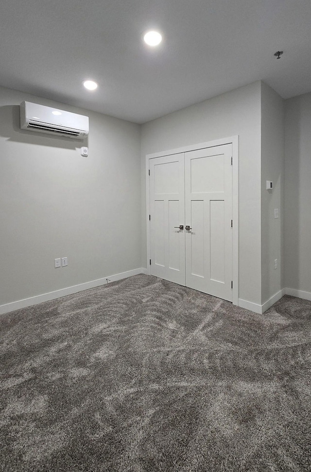 spare room with a wall mounted AC and carpet