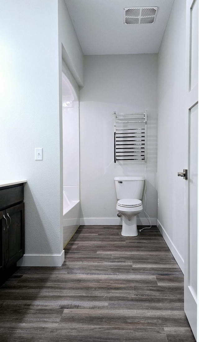 bathroom with vanity, a bath, radiator, toilet, and hardwood / wood-style flooring