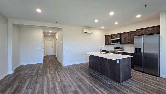 715 Lake Shore Dr NE Unit 113, Bemidji, MN 56601 - kitchen with stainless steel appliances, a sink, a wall mounted air conditioner, a kitchen island with sink, and dark wood-style flooring