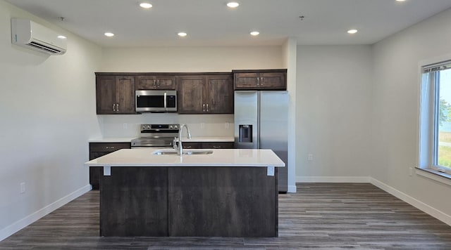 715 Lake Shore Dr NE Unit 113, Bemidji, MN 56601 - kitchen with stainless steel appliances, a wall mounted AC, a sink, dark brown cabinets, and a center island with sink