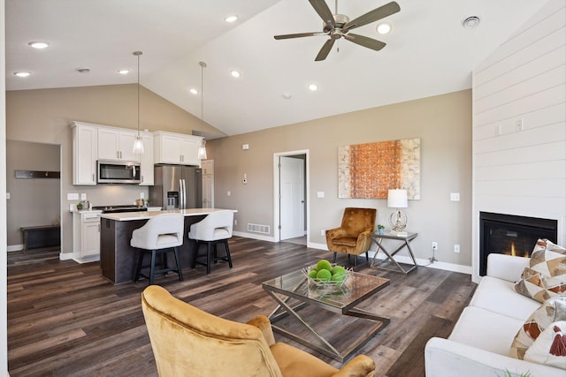 living room featuring dark wood-type flooring, ceiling fan, and high vaulted ceiling