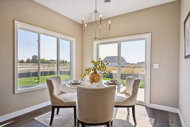 dining area with dark hardwood / wood-style flooring and a notable chandelier