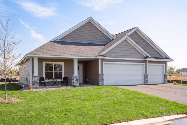 craftsman inspired home with a garage and a front yard