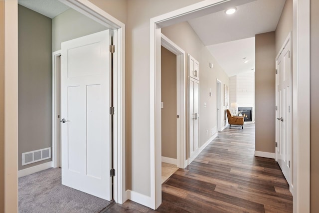 hallway with dark wood-type flooring and vaulted ceiling