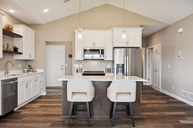 kitchen featuring white cabinetry, stainless steel appliances, sink, and hanging light fixtures