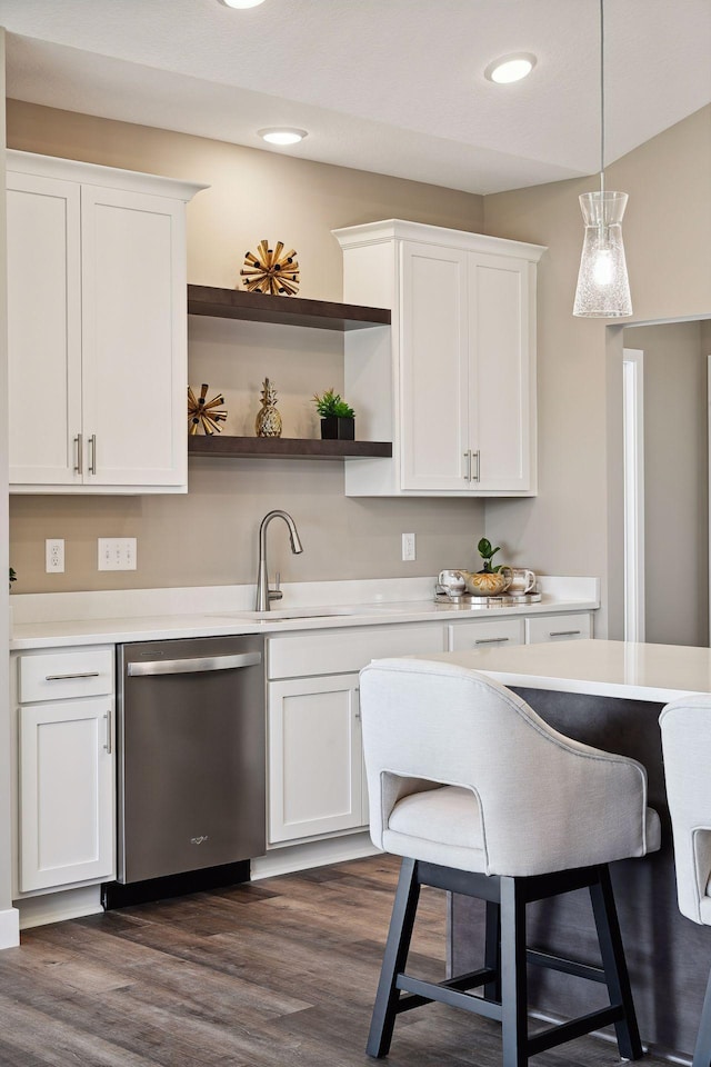 kitchen with dishwasher, decorative light fixtures, white cabinetry, sink, and dark hardwood / wood-style floors