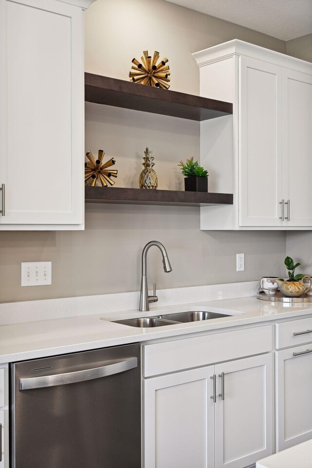 kitchen with dishwasher, white cabinetry, and sink