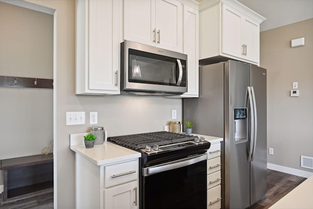 kitchen featuring dark wood-type flooring, appliances with stainless steel finishes, and white cabinetry