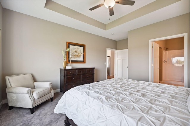 carpeted bedroom featuring ceiling fan, a tray ceiling, and connected bathroom