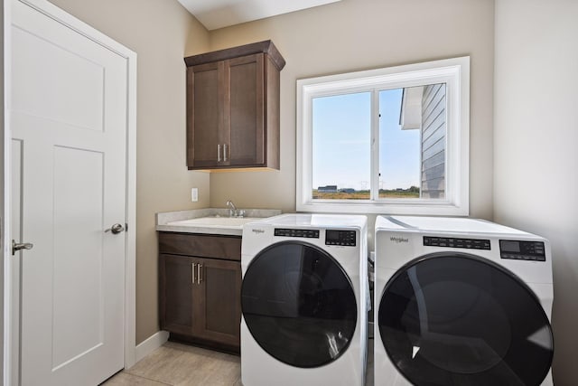 laundry area with separate washer and dryer, cabinets, and sink