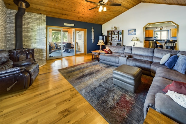 living room featuring wood ceiling, wood-type flooring, ceiling fan, and a wood stove