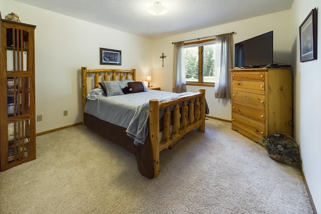 bedroom with light carpet and a textured ceiling