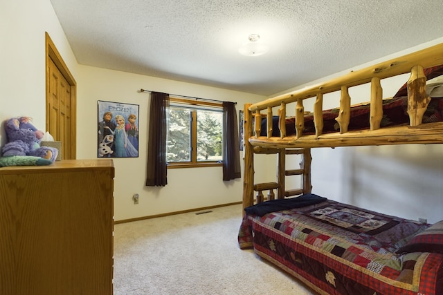 bedroom featuring light carpet and a textured ceiling