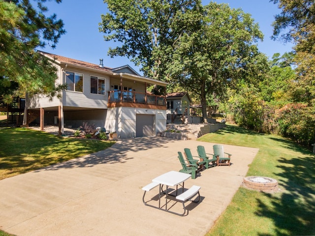 rear view of property featuring a garage, a lawn, and a patio