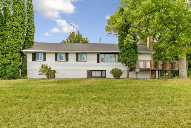 rear view of property featuring a wooden deck and a lawn