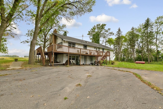 rear view of property with a yard and a deck