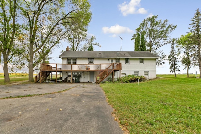 view of front of house with a wooden deck and a front lawn