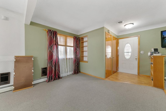 entrance foyer with wood-type flooring, baseboard heating, and a wealth of natural light