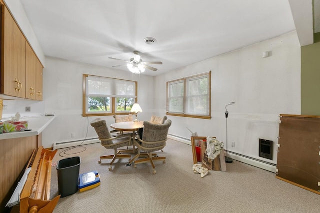 carpeted dining area with ceiling fan and a baseboard heating unit