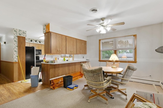 kitchen featuring ceiling fan, light hardwood / wood-style flooring, kitchen peninsula, and black appliances