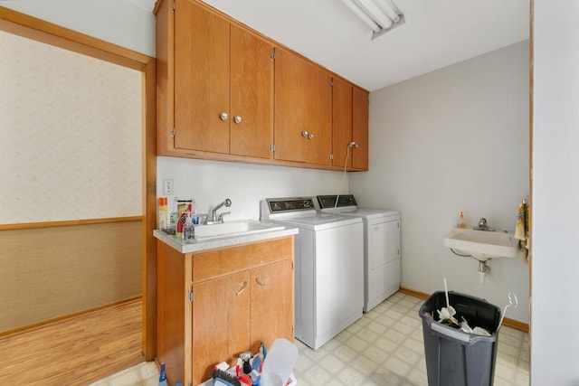 washroom featuring cabinets, separate washer and dryer, and sink