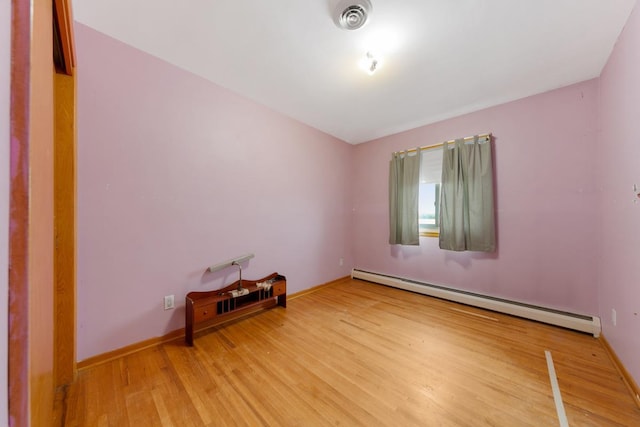 spare room with a baseboard radiator and hardwood / wood-style floors