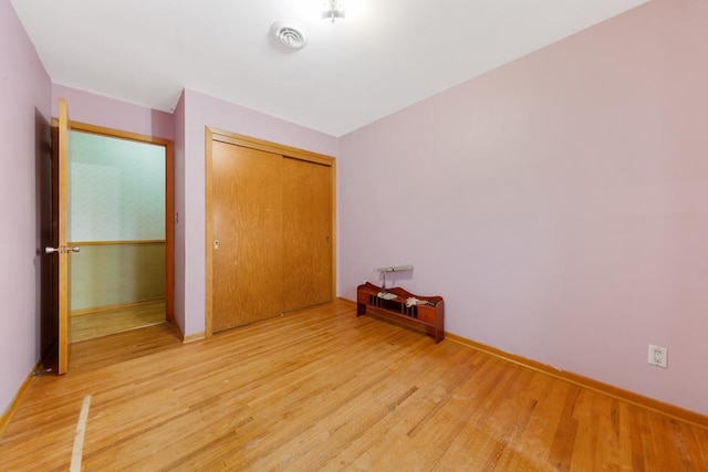 unfurnished bedroom with a closet and hardwood / wood-style flooring