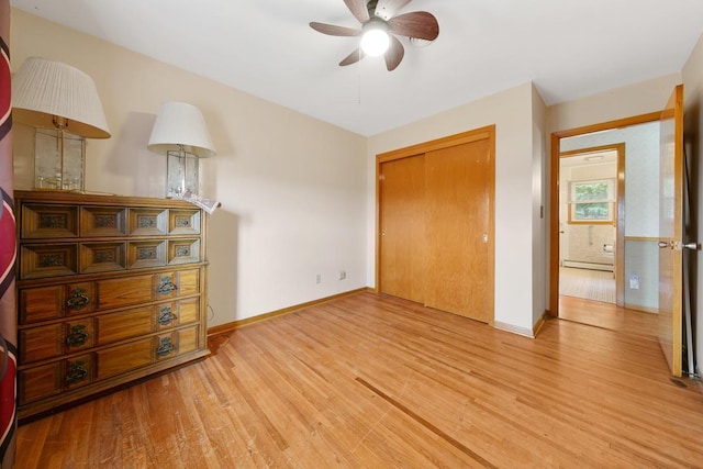 bedroom featuring ceiling fan, a closet, light hardwood / wood-style floors, and baseboard heating