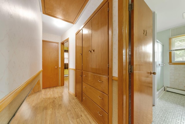 hallway with light hardwood / wood-style floors and a baseboard heating unit