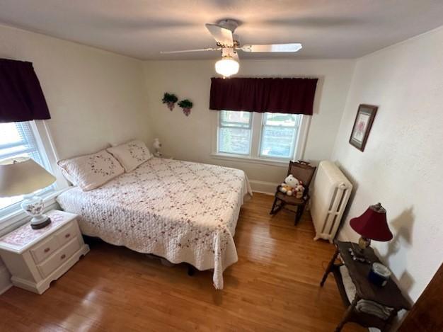 207 6th St, Montevideo, MN 56265 - bedroom featuring radiator heating unit, wood finished floors, and ceiling fan