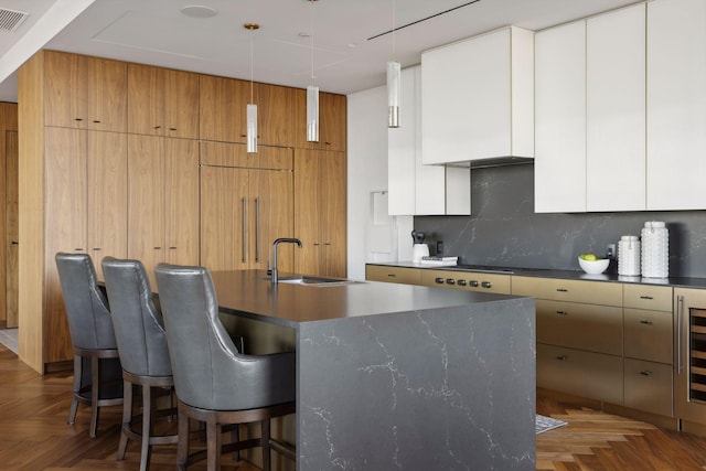 255 Hennepin Ave Unit 3402, Minneapolis, MN 55401 - kitchen with a kitchen bar, a sink, a kitchen island with sink, modern cabinets, and decorative backsplash