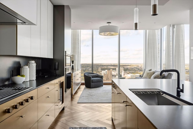 255 Hennepin Ave Unit 3402, Minneapolis, MN 55401 - kitchen featuring a sink, range hood, white cabinetry, modern cabinets, and stainless steel gas cooktop