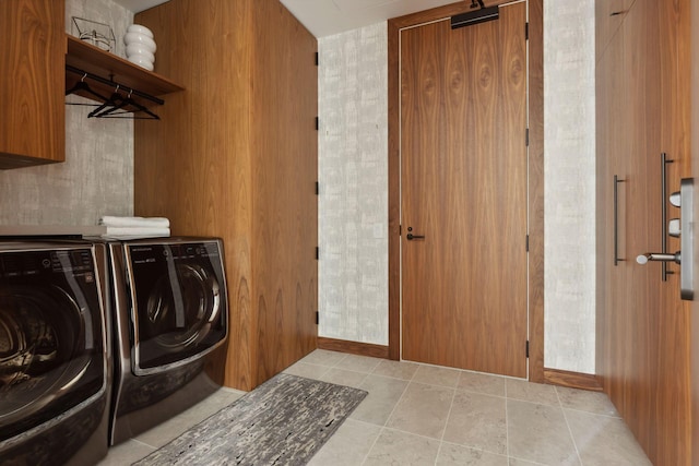 clothes washing area featuring cabinets, separate washer and dryer, and light tile patterned floors