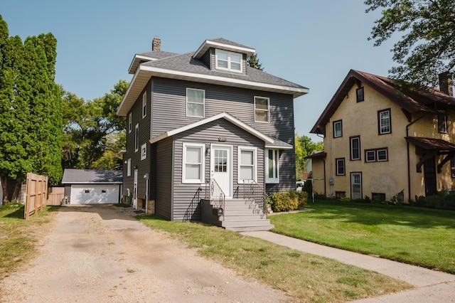 view of front of house featuring an outdoor structure, a garage, and a front lawn