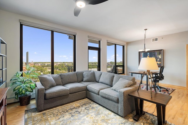 living room featuring baseboard heating, ceiling fan, and hardwood / wood-style flooring