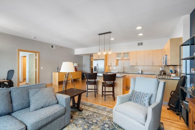 living room with sink and light hardwood / wood-style floors