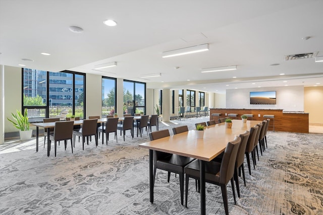 carpeted dining area with a wall of windows