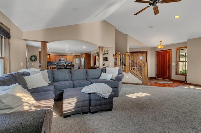 carpeted living room featuring decorative columns, lofted ceiling, and ceiling fan