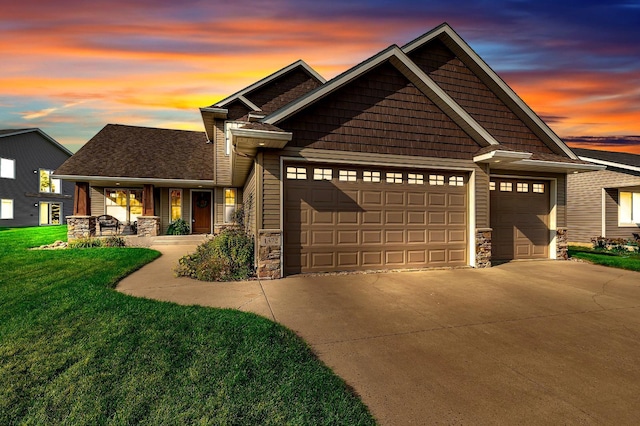 craftsman-style house with a garage, covered porch, and a lawn