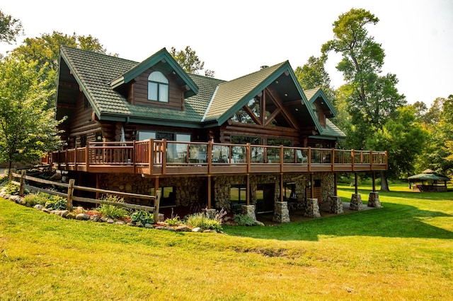 back of property featuring a deck and a lawn